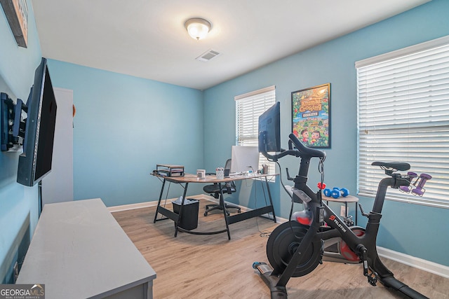 exercise area with light hardwood / wood-style flooring