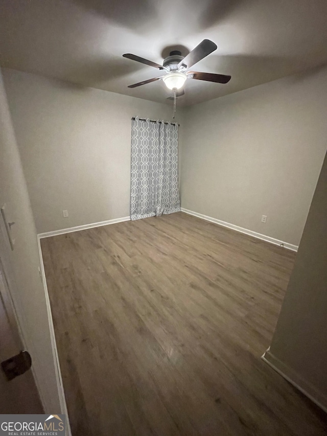 spare room featuring dark hardwood / wood-style floors and ceiling fan