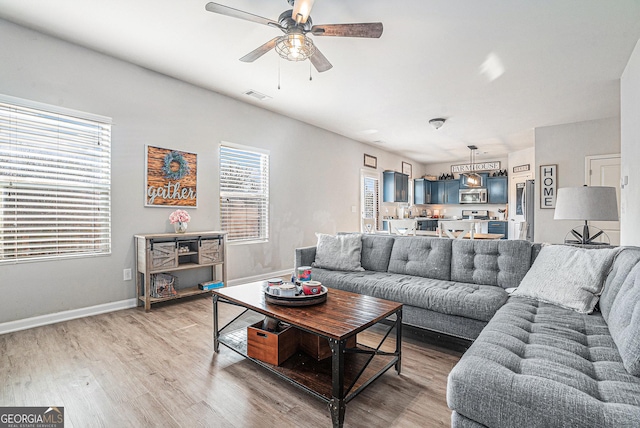 living room featuring hardwood / wood-style flooring and ceiling fan