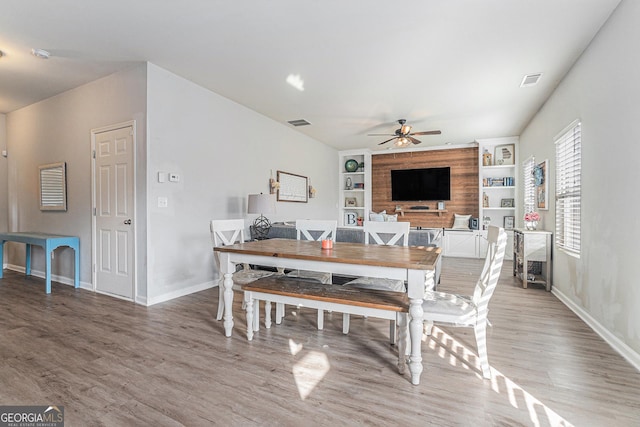 dining room with hardwood / wood-style flooring, ceiling fan, and built in features