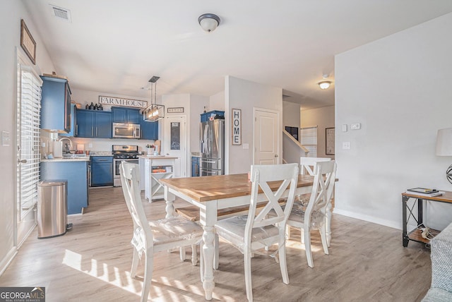 dining room with sink and light hardwood / wood-style floors