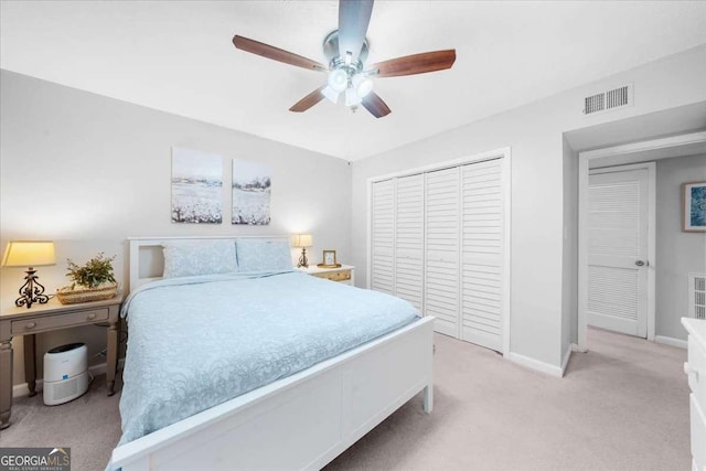 bedroom with ceiling fan, a closet, and light colored carpet