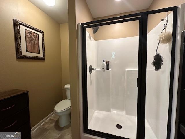 bathroom with tile patterned floors, toilet, and walk in shower