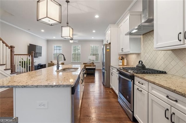 kitchen featuring stainless steel appliances, a kitchen island with sink, sink, wall chimney range hood, and white cabinetry