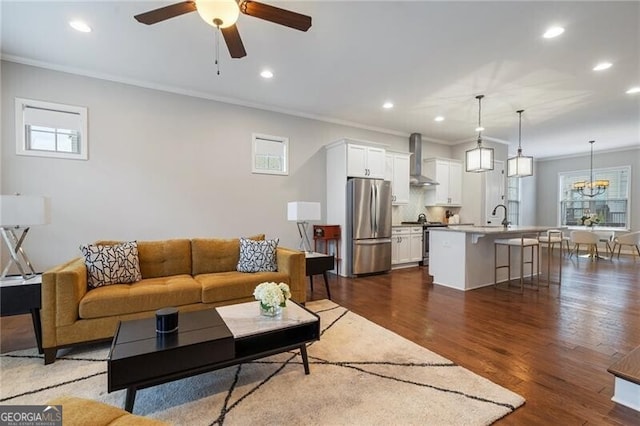 living room featuring ceiling fan with notable chandelier, plenty of natural light, and crown molding