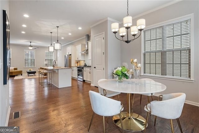 dining area featuring ceiling fan with notable chandelier, dark hardwood / wood-style floors, crown molding, and sink