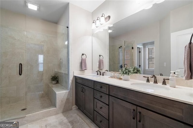 bathroom with a shower with door, vanity, and tile patterned flooring