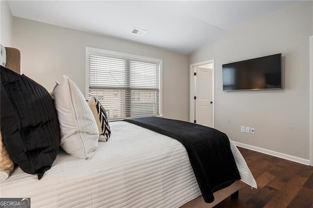 bedroom featuring lofted ceiling and dark hardwood / wood-style floors