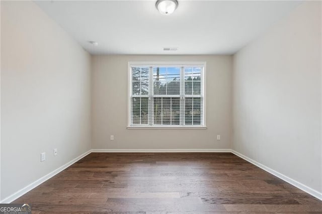 unfurnished room with dark hardwood / wood-style floors