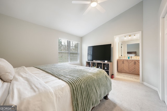 bedroom with carpet flooring, ceiling fan, ensuite bath, and vaulted ceiling