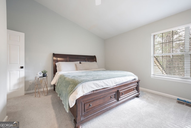 carpeted bedroom with ceiling fan and vaulted ceiling