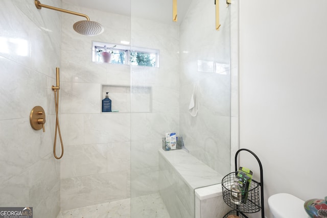 bathroom featuring toilet and a tile shower