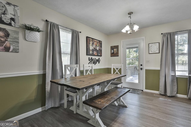 dining area with a chandelier, visible vents, baseboards, and wood finished floors