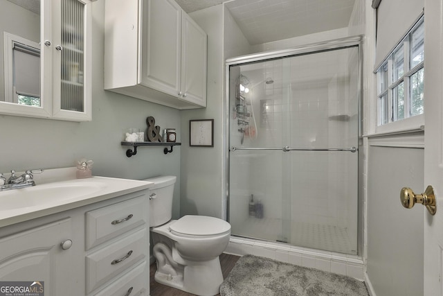 bathroom with a stall shower, vanity, and toilet