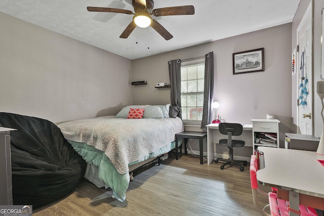 bedroom featuring a ceiling fan, baseboards, and wood finished floors