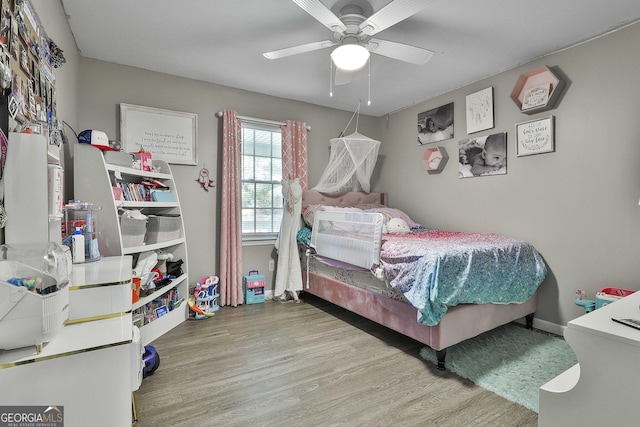 bedroom with ceiling fan, baseboards, and wood finished floors