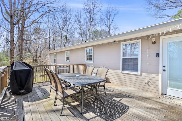 deck with outdoor dining space and area for grilling