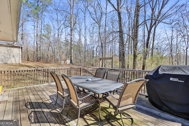 wooden terrace featuring outdoor dining area and area for grilling