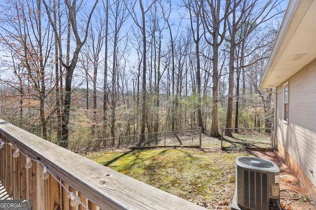 view of yard featuring a forest view, cooling unit, and fence