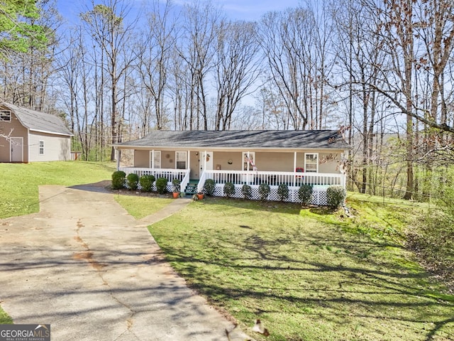 view of front of home with covered porch, driveway, a front yard, and an outdoor structure