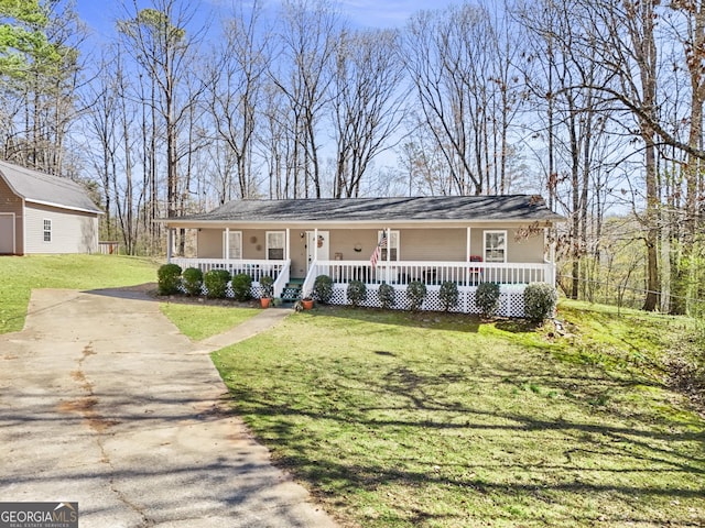 view of front of property featuring an outbuilding, a porch, concrete driveway, and a front yard