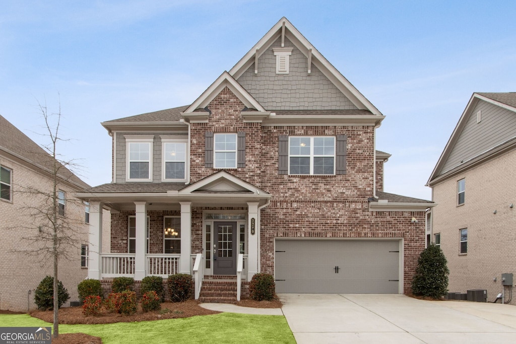 craftsman-style home featuring covered porch, a garage, and cooling unit