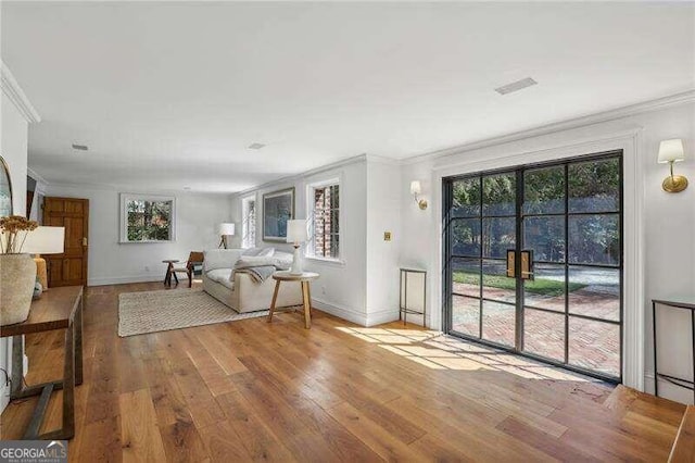 unfurnished living room with crown molding and wood-type flooring