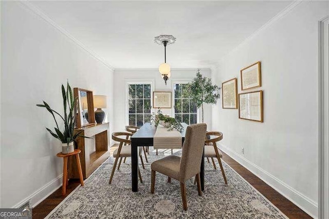 dining space featuring dark wood-type flooring and ornamental molding