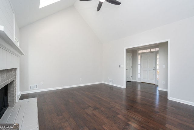 unfurnished living room featuring ceiling fan, dark hardwood / wood-style flooring, high vaulted ceiling, and a brick fireplace