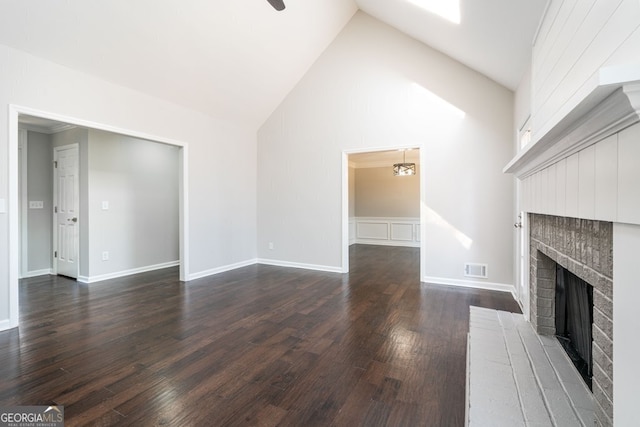 unfurnished living room featuring dark hardwood / wood-style flooring, a fireplace, and high vaulted ceiling