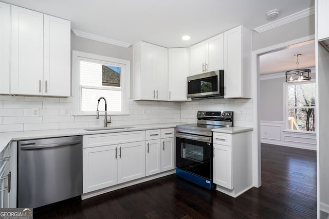 kitchen featuring white cabinetry, sink, stainless steel appliances, dark hardwood / wood-style floors, and ornamental molding