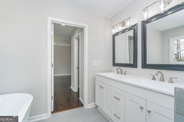 bathroom with a bathing tub, tile patterned flooring, and vanity