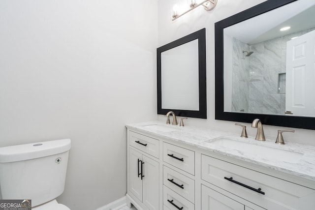 bathroom featuring toilet, vanity, and tiled shower