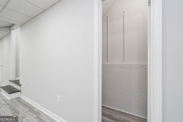 interior space with a paneled ceiling and wood-type flooring