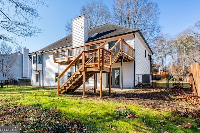 rear view of house with central air condition unit, a yard, and a deck