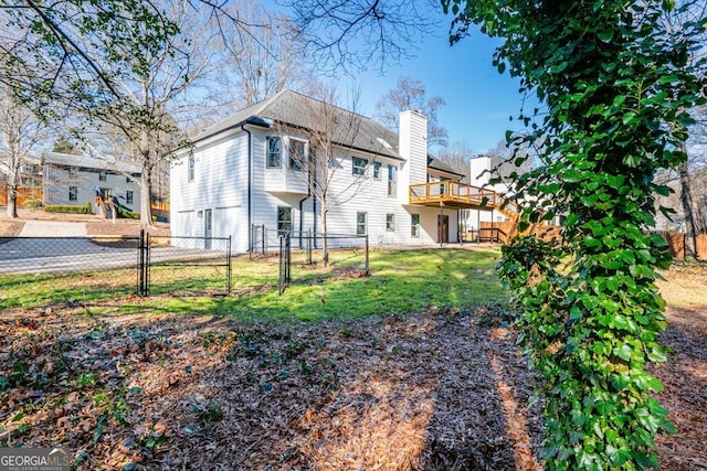 rear view of property with a wooden deck and a yard