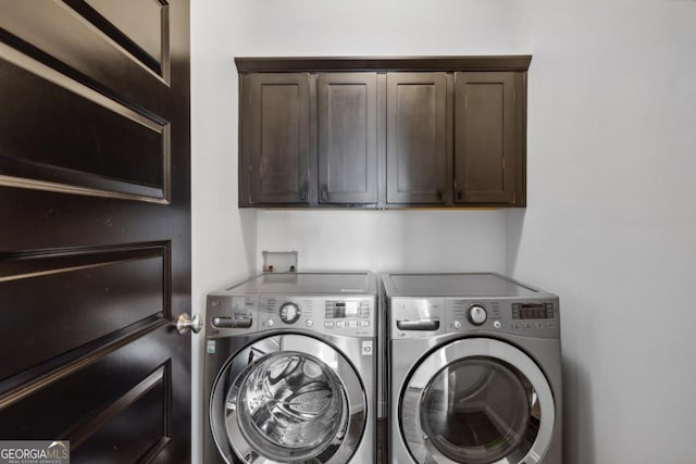 washroom featuring cabinets and washing machine and clothes dryer