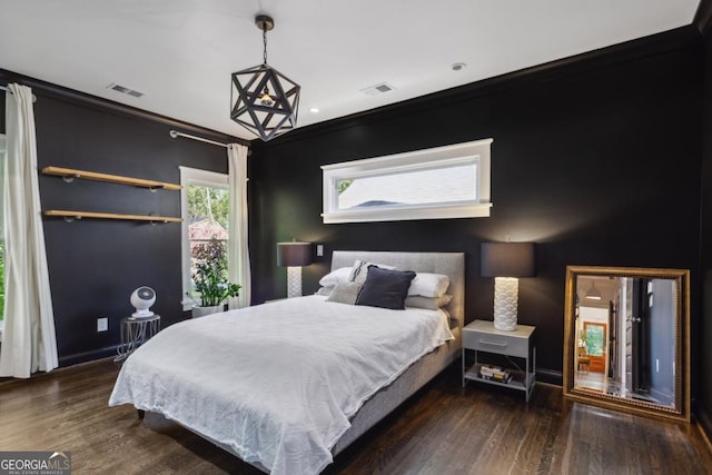 bedroom with dark hardwood / wood-style floors and crown molding