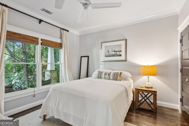 bedroom with dark hardwood / wood-style floors, ceiling fan, and crown molding