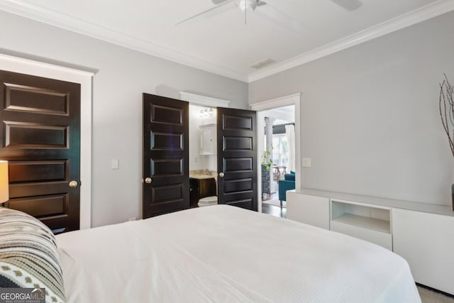 bedroom featuring ceiling fan, ensuite bathroom, and crown molding