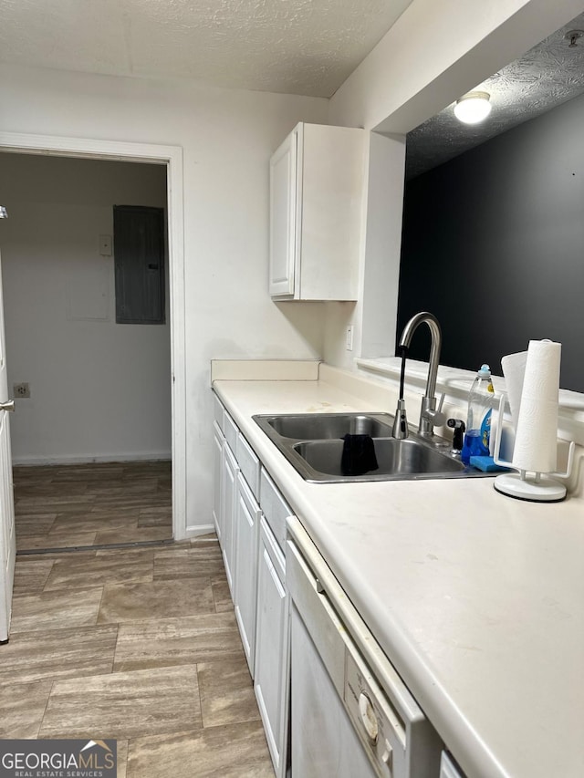 kitchen featuring dishwasher, sink, electric panel, a textured ceiling, and white cabinets