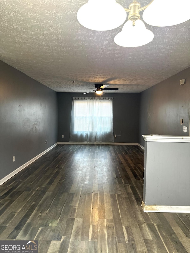 unfurnished room with dark hardwood / wood-style floors, ceiling fan, and a textured ceiling