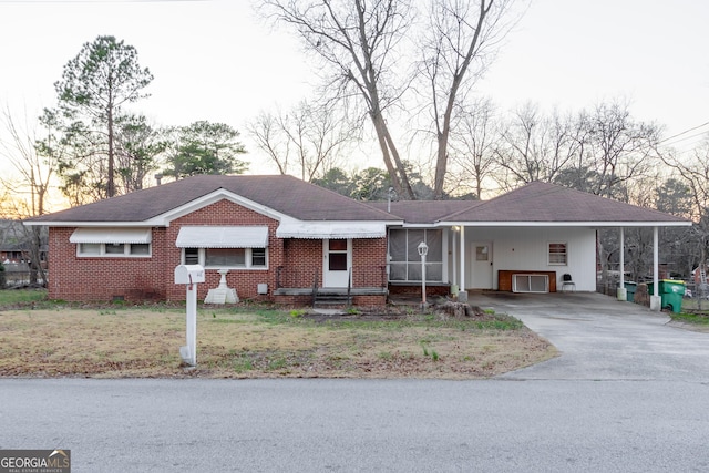 single story home featuring a front lawn and a carport