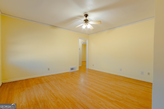 unfurnished room with hardwood / wood-style floors, ceiling fan, and crown molding