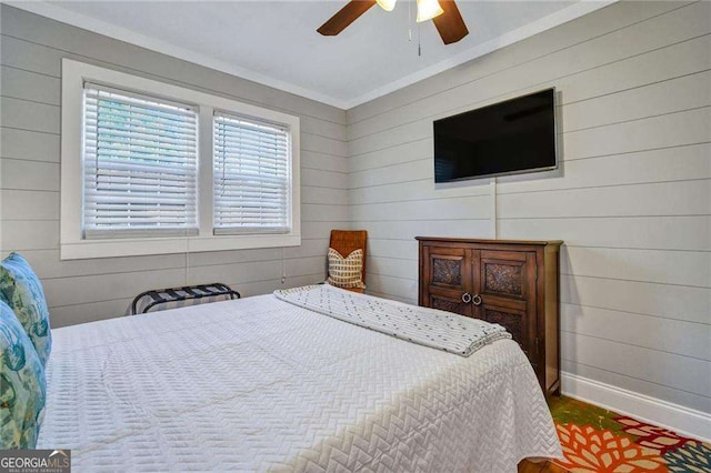 bedroom featuring ceiling fan, crown molding, and wood walls