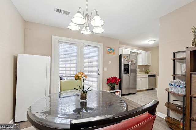 dining room with light hardwood / wood-style floors and an inviting chandelier