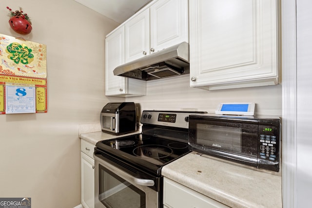 kitchen featuring electric range and white cabinets