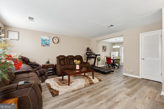 living room featuring light hardwood / wood-style flooring and an inviting chandelier