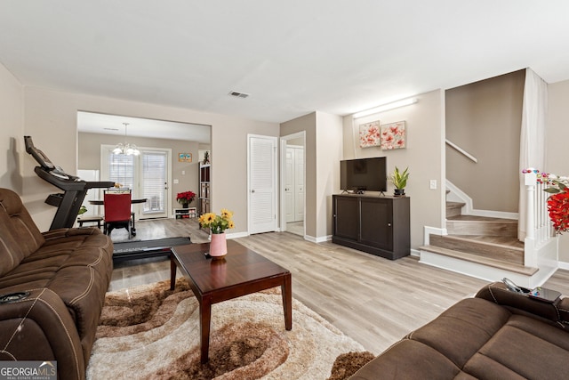 living room featuring light hardwood / wood-style floors and an inviting chandelier