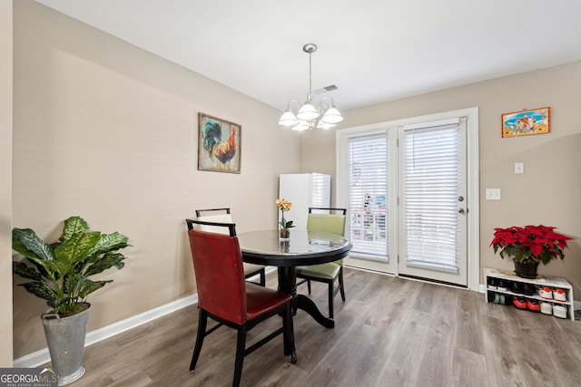 dining area with a chandelier and wood-type flooring